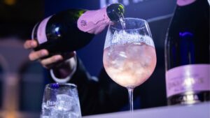 Botella de vino espumoso Tacama junto a copa con burbujas